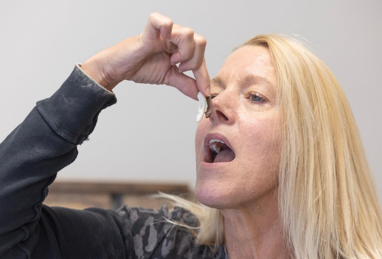 Teresa Kerekes, office manager at State Termite and Pest Solutions in North Canton, makes it look like she's going to try one of the chocolate covered bugs the company will offer during the North Canton Chocolate Walk on Saturday, Sept. 30, 2023. She didn't actually eat it, though.