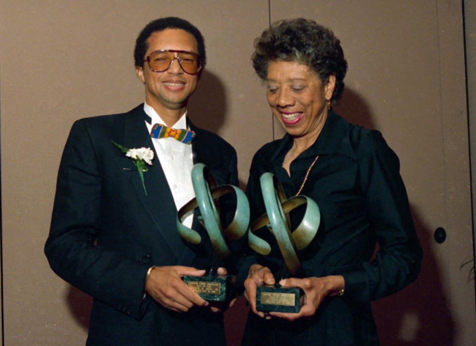 FILE - In this May 13, 1988, file photo, tennis players Arthur Ashe, left, and Althea Gibson pose while holding trophies after being inducted into the Eastern Tennis Association Hall of Fame in New York. Gibson won an amazing 11 Grand Slam titles in three years from 1956-58, including the French Open, Wimbledon and U.S. Open. On Monday, Aug. 26, 2019, the USTA will unveil a statue in her honor at the U.S. Open. (AP Photo/Susan Ragan, File)