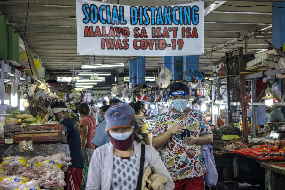 FILE PHOTO: Filipinos are seen wearing face masks and face shields inside a wet market on August 19, 2020 in Quezon City, Philippines. (Photo by Ezra Acayan/Getty Images)