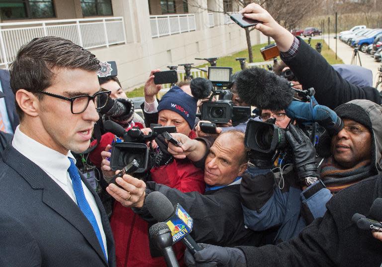 Olympic swimming champion Michael Phelps (L) speaks to the press after his trial on December 19, 2014 at the John R. Hargrove, Sr. District Court Building in Baltimore, Maryland