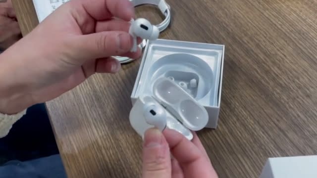 Someone holds fake Apple Air Pods