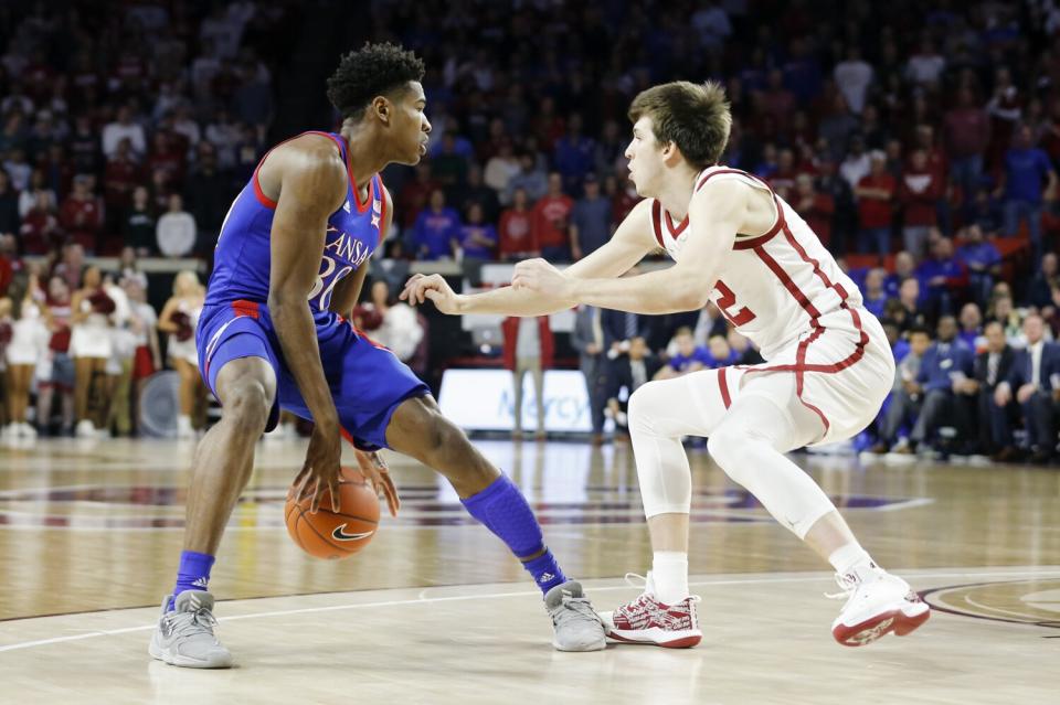 Kansas' Ochai Agbaji (30) is defended by Oklahoma's Austin Reaves