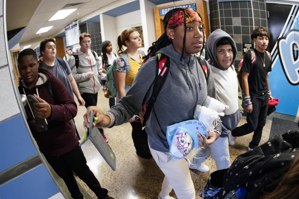 Students at the Washington Junior High School leaving classes for the day, use the unlocking mechanism to open the bags their cell phone were sealed in during the school day, Thursday, Oct. 27, 2022, in Washington, Pa. Citing mental health, behavior and engagement as the impetus, many educators are updating cellphone policies, with a number turning to magnetically sealing pouches. (AP Photo/Keith Srakocic)