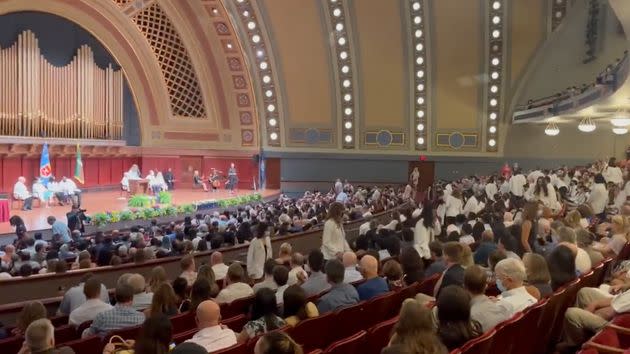 Dozens of incoming medical students at the University of Michigan walk out of the school’s annual White Coat Ceremony as Dr. Kristin Collier begins to speak. (Photo: Screenshot @PEScorpiio/Twitter)