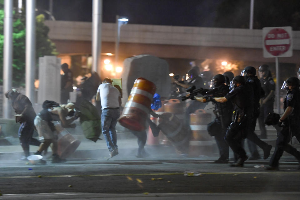 Police officers force a line of demonstrators away from the front of the Public Safety Building in Rochester, N.Y., Thursday, Sept. 3, 2020. Seven police officers involved in the suffocation death of Daniel Prude in Rochester were suspended Thursday by the city's mayor, who said she was misled for months about the circumstances of the fatal encounter. (AP Photo/Adrian Kraus)