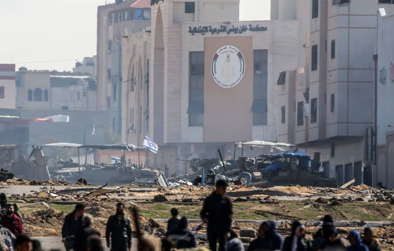 Israeli tanks roll along a position as Palestinians flee Khan Yunis to safer areas further South of Gaza Strip through the City's western exit on the outskirts of its refugee camp. Abed Rahim Khatib/dpa