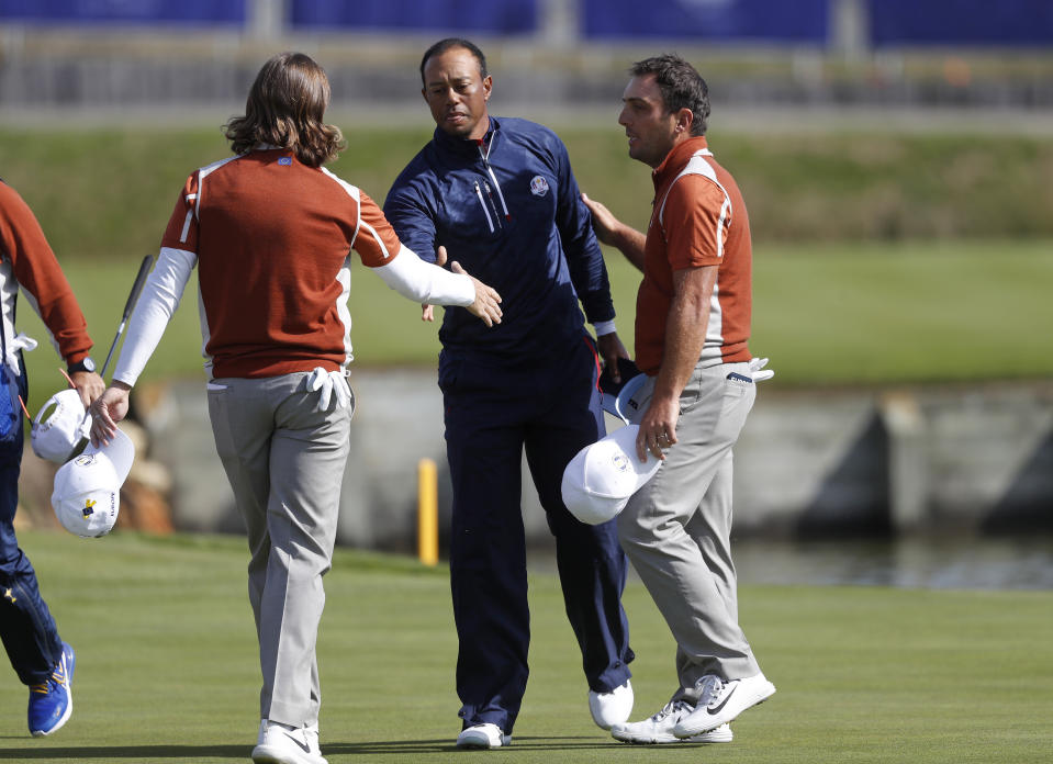 Europe's Tommy Fleetwood, left, and Francesco Molinari greet Tiger Woods of the US after a fourball match on the second day of the 42nd Ryder Cup at Le Golf National in Saint-Quentin-en-Yvelines, outside Paris, France, Saturday, Sept. 29, 2018. Fleetwood and Molinari beat Woods and Patrick Reed of the US 4 and 3. (AP Photo/Alastair Grant)