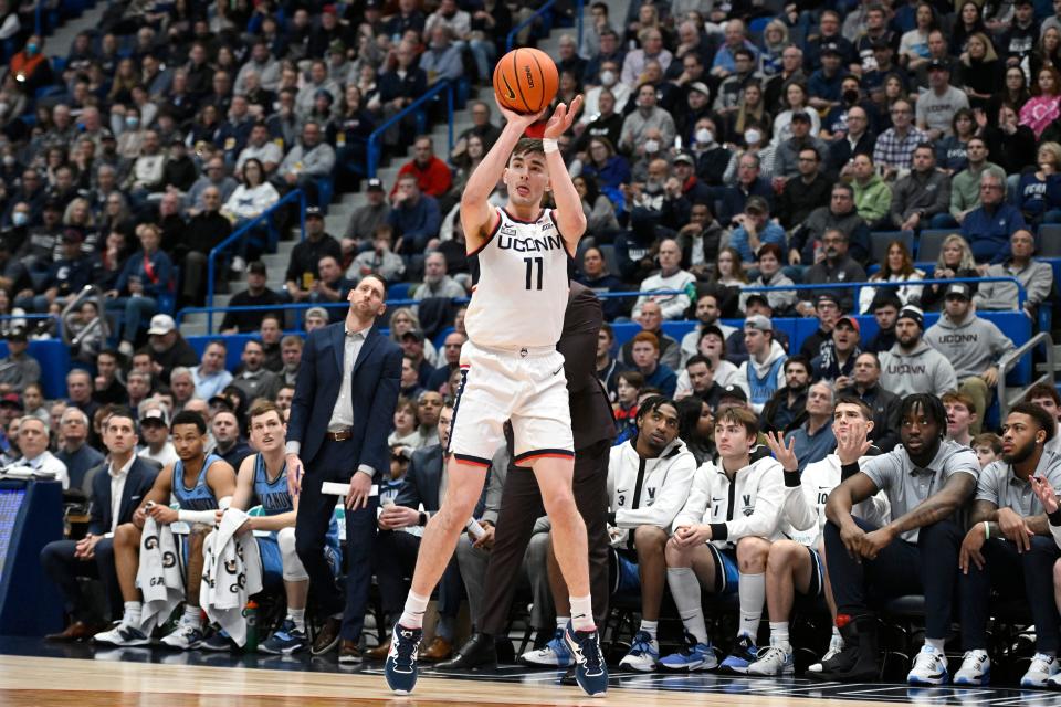 UConn's Alex Karaban makes a 3-point basket in the first half of an NCAA college basketball game as Villanova looks on.
