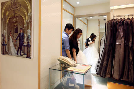 Daphne Chiang (R), 32, an insurance consultant, tries on a wedding dress with her same-sex partner Kenny Jhuang, 33, a service worker in Taipei, Taiwan. "Once it passes we'll have everything, further protection," Chiang said. "But before that, we have to make the most of what we have." REUTERS/Tyrone Siu