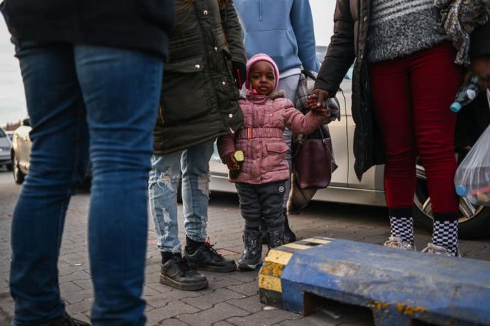 A Nigerian child stands next to her mother after arriving by bus to a supermarket parking lot from the Polish-Ukrainian border crossing February 26, 2022 in Przemysl, Poland. More than 30, 000 people have crossed the border into Poland from Ukraine in the first two days of the Russian invasion. The Ukrainian government issued order to stop 18-60 year-old men legible for military conscription from crossing borders. On February 24, 2022 Russia began a large-scale attack on Ukraine, with Russian troops invading the country from the north, east and south, accompanied by air strikes and shelling. The Ukrainian president said that at least 137 Ukrainian soldiers were killed by the end of the first day.