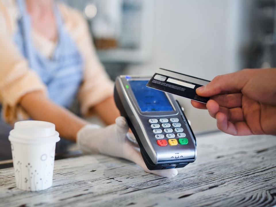 Contactless payment with debit card, coffee shop open after lockdown.