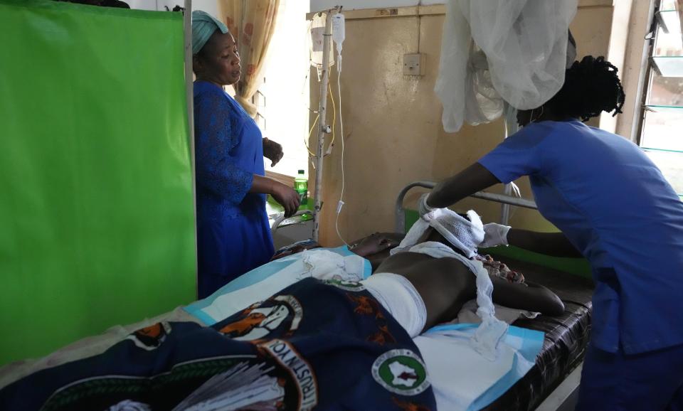 A woman looks at her daughter, who was involved in the St. Francis Catholic Church attack, as she receives treatment at St Louis Catholic Hospital in Owo Nigeria, Monday, June 6, 2022. Lawmakers in southwestern Nigeria say more than 50 people are feared dead after gunmen opened fire and detonated explosives at a church. Ogunmolasuyi Oluwole with the Ondo State House of Assembly said the gunmen targeted the St Francis Catholic Church in Ondo state on Sunday morning just as the worshippers gathered for the weekly Mass. (AP Photo/Sunday Alamba)