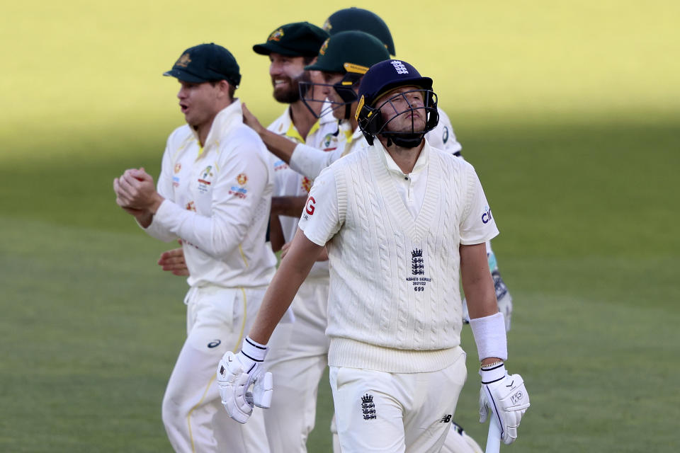 England's Ollie Robinson, front, walks off after he was caught out by Australia's Steve Smith, left, during the fifth day of their Ashes cricket test match in Adelaide, Australia, Monday, Dec. 20, 2021. (AP Photo/James Elsby)