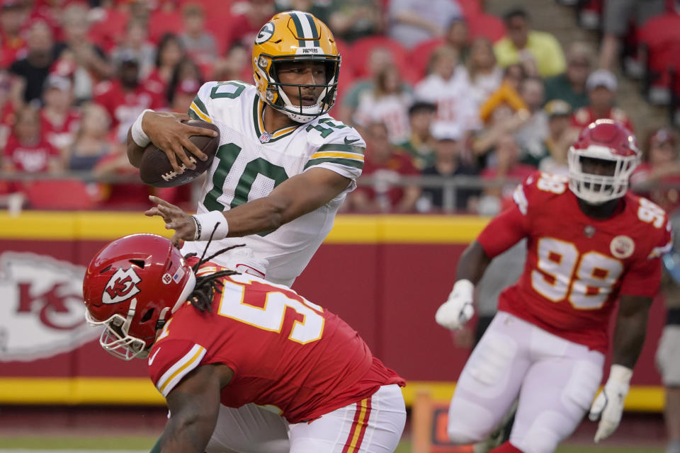 Green Bay Packers quarterback Jordan Love (10) runs with the ball as Kansas City Chiefs defensive end Mike Danna and defensive tackle Tershawn Wharton (98) defend during the first half of an NFL preseason football game Thursday, Aug. 25, 2022, in Kansas City, Mo. (AP Photo/Ed Zurga)