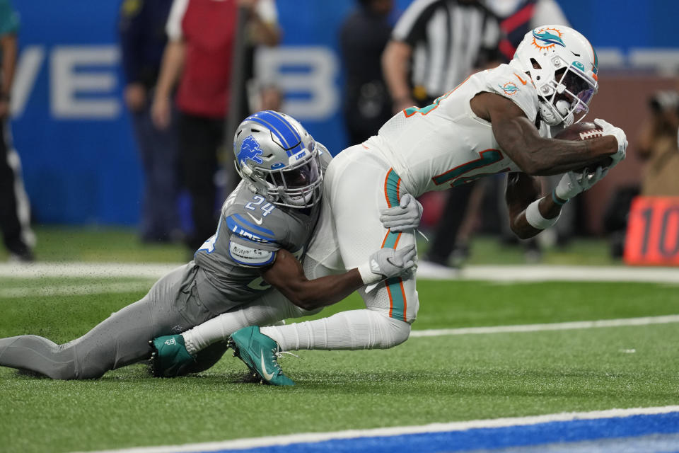 Miami Dolphins wide receiver Trent Sherfield, defended by Detroit Lions cornerback Amani Oruwariye (24) falls into the end zone for a touchdown during the second half of an NFL football game, Sunday, Oct. 30, 2022, in Detroit. (AP Photo/Paul Sancya)