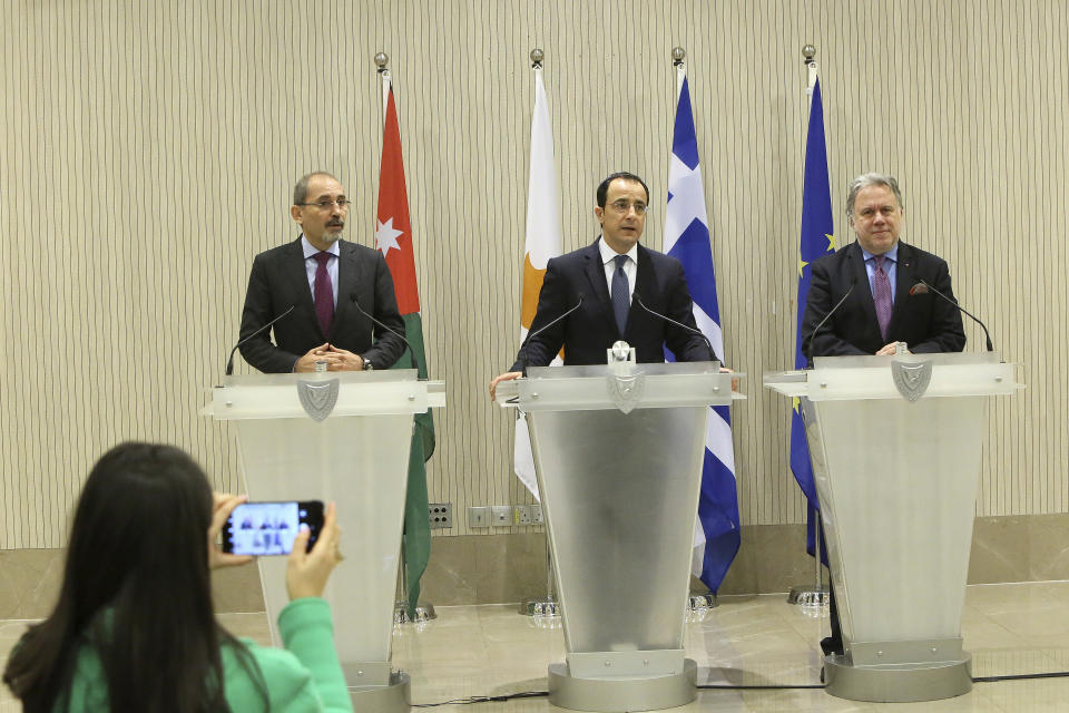 Cypriot foreign minister Nicos Christodoulides, center, Foreign minister of Jordan Ayman Safadi, left, and the Greek Alternate Minister of Foreign Affairs Georgios Katrougalos talk to the media during a press conference after their meeting at the presidential palace in Nicosia, Cyprus, Wednesday, Dec. 19, 2018. The three ministers are meeting in the Cypriot capital to explore ways of strengthening ties on fields as varied as education and entrepreneurship. (AP Photo/Petros Karadjias)