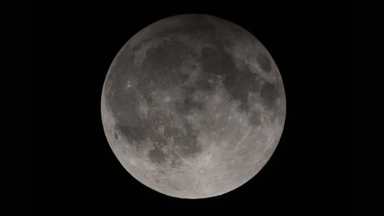  a dark shadow lies across the top of the moon 