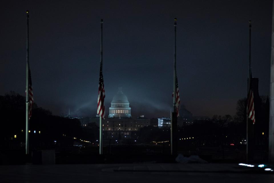 The U.S. flag flies at half-staff in front of the Washington Monument and U.S. Capitol in tribute to former President George H.W. Bush, early on Dec. 2. (Photo: Alex Edelman/AFP/Getty Images)