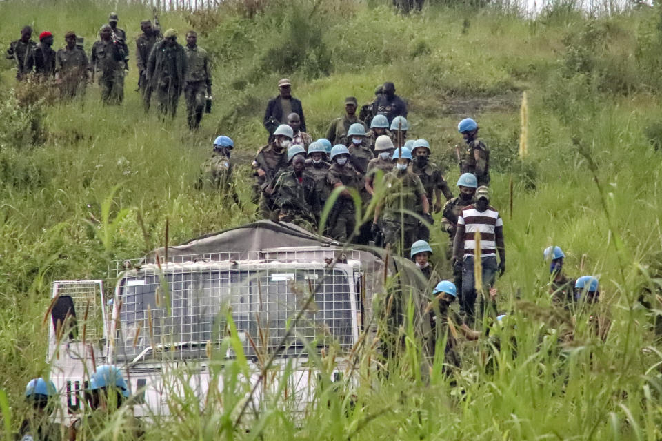 United Nations peacekeepers remove bodies from an area near to where a U.N. convoy was attacked and the Italian ambassador to Congo killed, in Nyiragongo, North Kivu province, Congo Monday, Feb. 22, 2021. The Italian ambassador to Congo Luca Attanasio, an Italian Carabineri police officer and their Congolese driver were killed Monday in an attack on a U.N. convoy in an area that is home to myriad rebel groups, the Foreign Ministry and local people said. (AP Photo/Justin Kabumba)