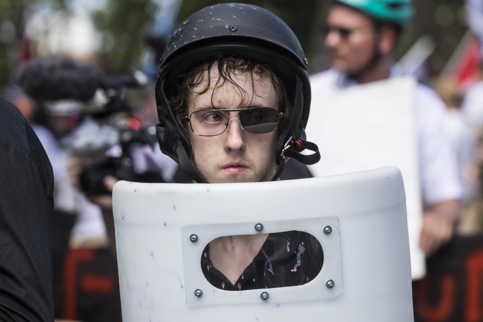 <p>A White Supremacists with one lens knocked out of his sunglasses holds up a shield during clashes with counter protestors at Emancipation Park where the White Nationalists are protesting the removal of the Robert E. Lee monument in Charlottesville, Va., on Aug. 12, 2017. (Photo: Samuel Corum/Anadolu Agency/Getty Images) </p>