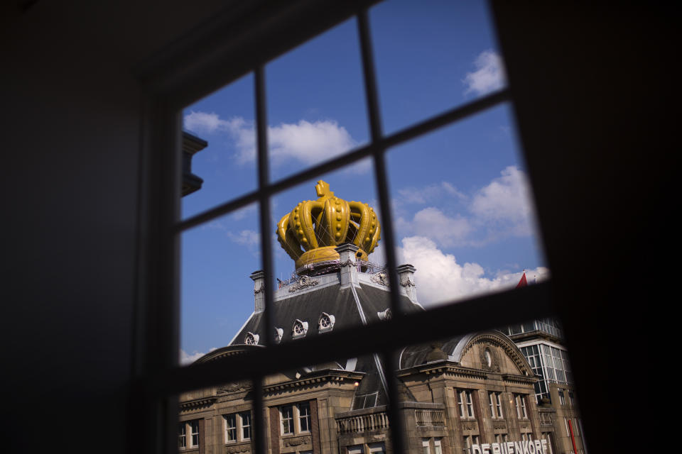 A large inflatable crown sits on top of a building in downtown Amsterdam, Netherlands Sunday, April 28, 2013. Queen Beatrix announced she will relinquish the crown on April 30, 2013, after 33 years of reign, leaving the monarchy to her son Crown Prince Willem Alexander. (AP Photo/Emilio Morenatti)