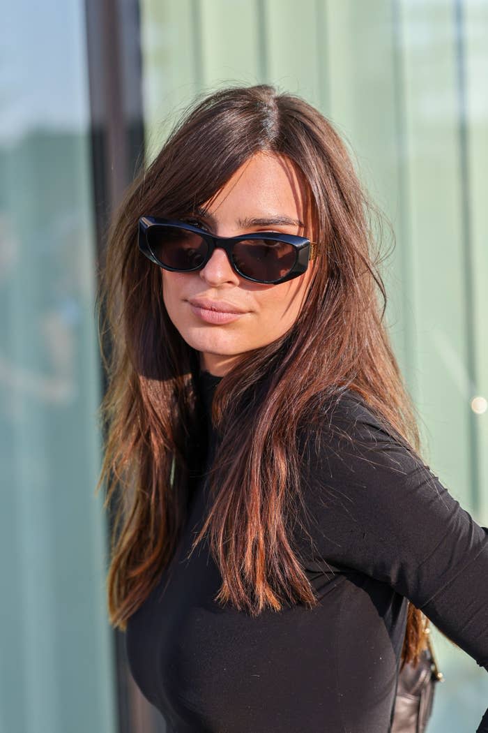 A closeup of Emily wearing a long-sleeved shirt and sunglasses