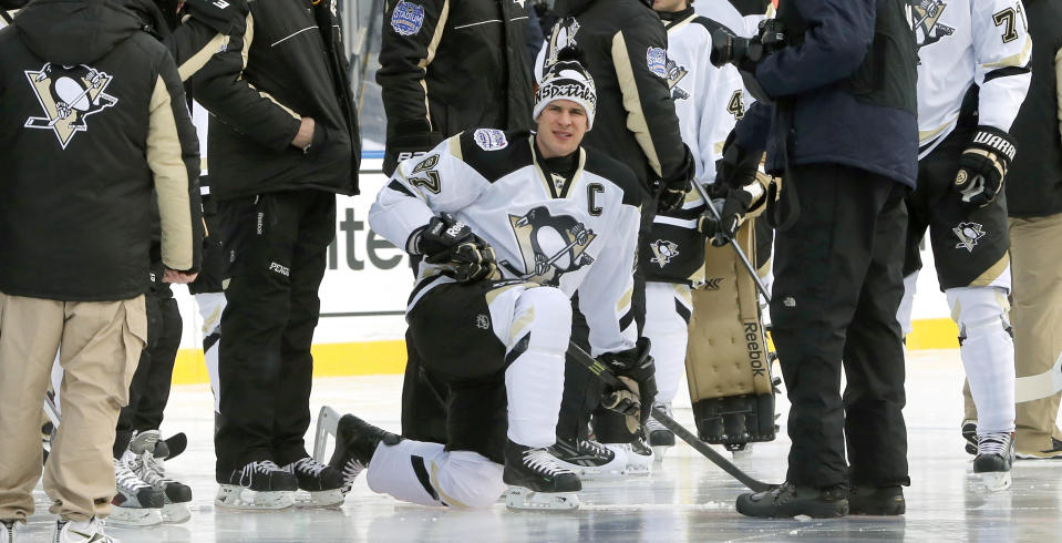 Pittsburgh Penguins' Sidney Crosby gets in place for a team photo on the Soldier Field ice for Saturday's Stadium Series NHL hockey game between the Penguins and the Chicago Blackhawks, Friday, Feb. 28, 2014, in Chicago. (AP Photo/Charles Rex Arbogast)