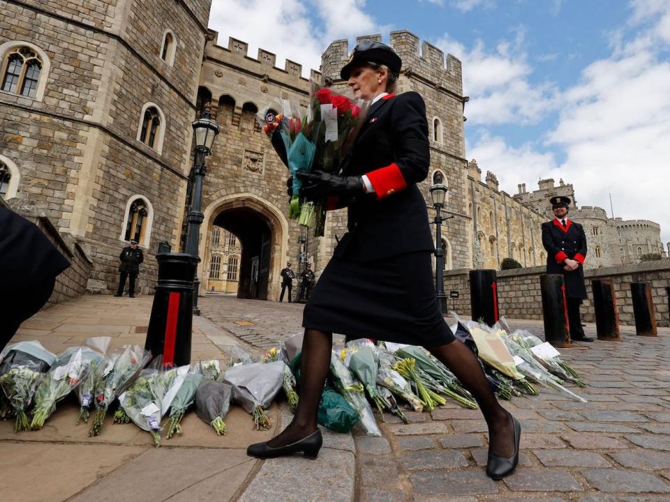 Wardens of the Castle move floral tributes to the side of the driveway at the Henry VIII Gate of Windsor Castle, in Windsor, west of London, on April 9, 2021, following the announcement of the death of Britain's Prince Philip. Adrian Dennis:AFP:Getty