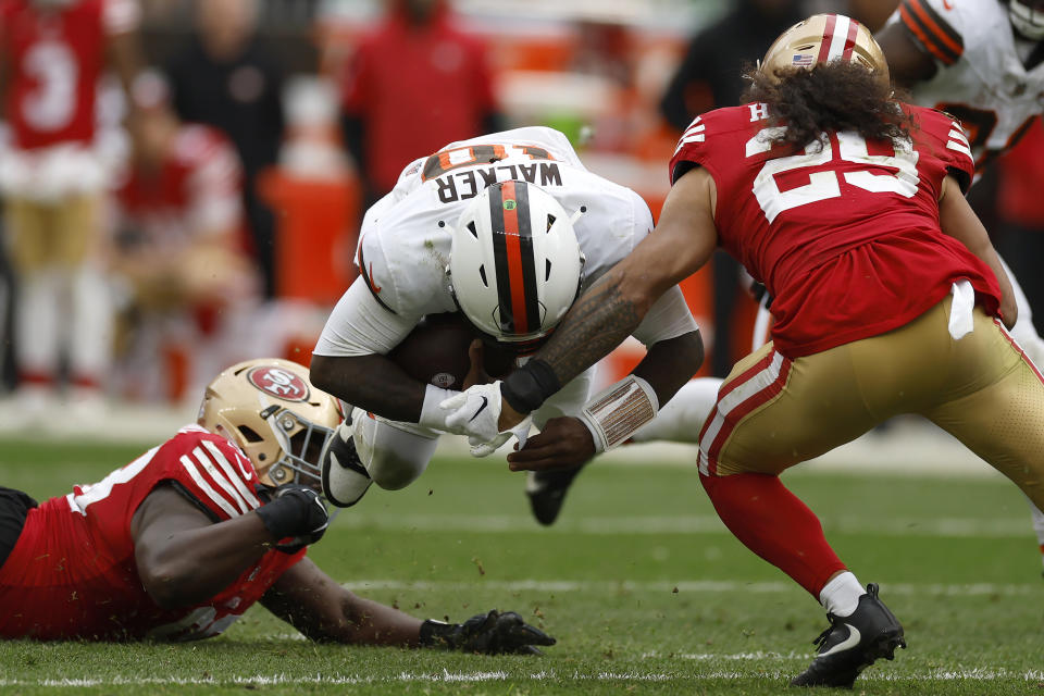 Cleveland Browns quarterback PJ Walker, middle, dives between San Francisco 49ers defensive tackle Javon Hargrave, left, and safety Talanoa Hufanga (29) during the second half of an NFL football game Sunday, Oct. 15, 2023, in Cleveland. (AP Photo/Ron Schwane)