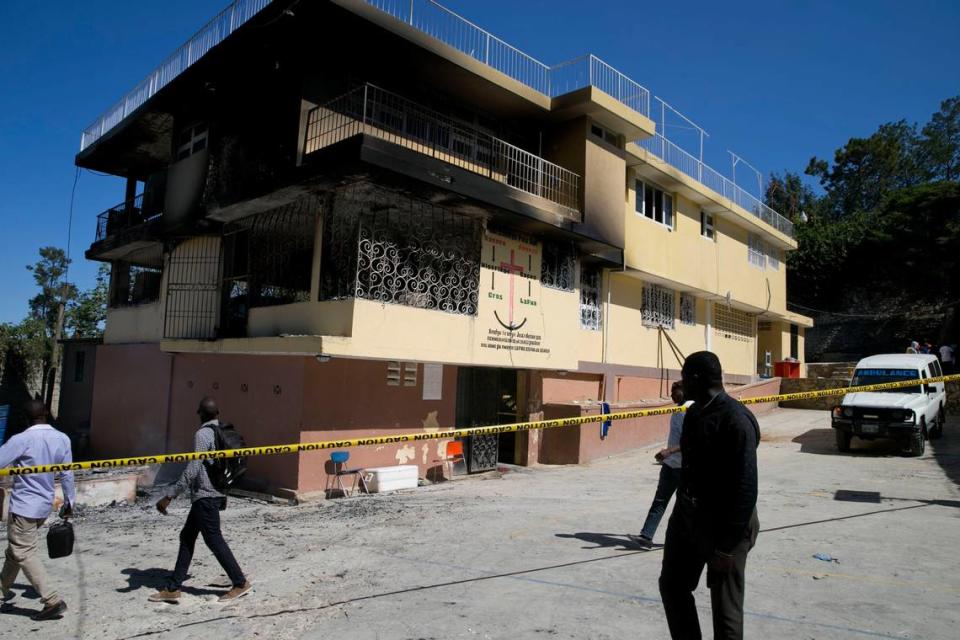 People walk past the Orphanage of the Church of Bible Understanding where a fire the previous night took the lives of 15 children.