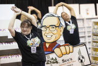 Michelle King of San Francisco does yoga in the See's Candies booth before the arrival of shareholders for the Berkshire Hathaway annual meeting on Saturday, May 4, 2024, in Omaha, Neb. (AP Photo/Rebecca S. Gratz)