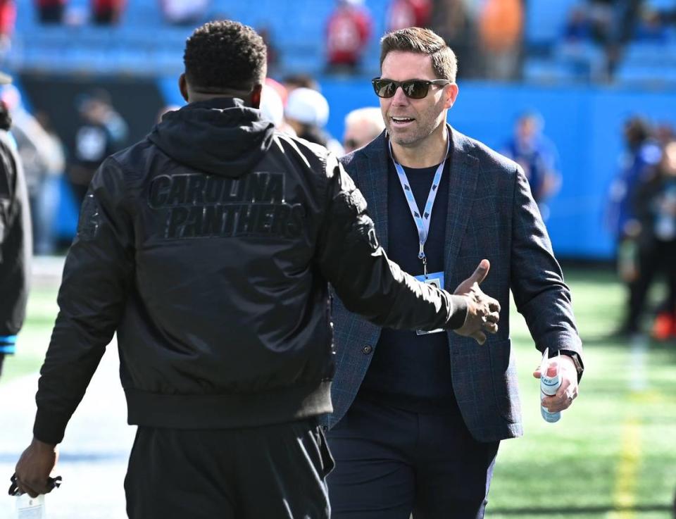 Former Carolina Panthers linebacker Thomas Davis, back to camera, greets then-assistant general manager Dan Morgan, right, along the team’s sideline at Bank of America Stadium in Charlotte, NC on Sunday, January 7, 2024. On Monday, January 8, 2024, team general manager Scott Fitterer was fired after three seasons following the team’s 9-0 loss to the Tampa Bay Buccaneers. JEFF SINER/jsiner@charlotteobserver.com