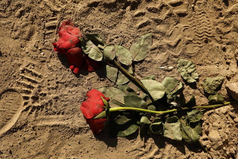 Flowers lie in the dirt after numerous funeral are held every day.
