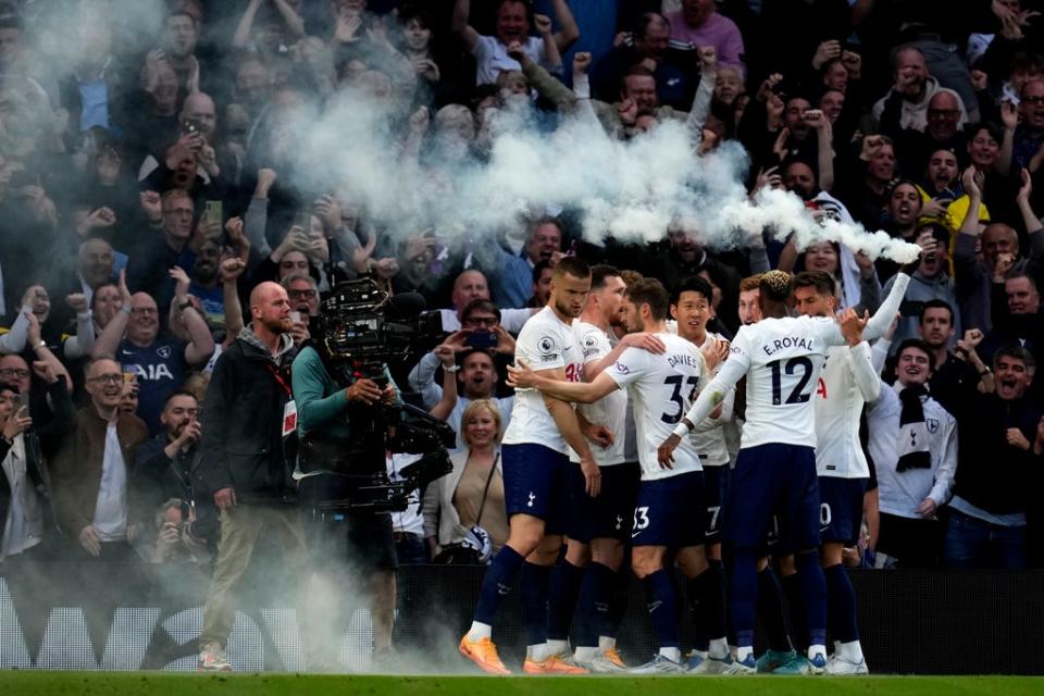 Tottenham’s Emerson Royal holds up a flare as he celebrates with his teammates (AP)
