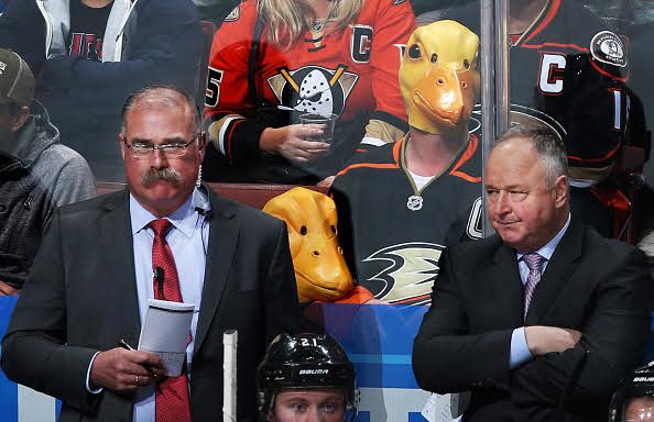 ANAHEIM, CA - MARCH 15: Two fans wear duck masks as assistant coach, Paul MacLean, and head coach Randy Carlyle of the Anaheim Ducks watch the game against the St. Louis Blues on March 15, 2017 at Honda Center in Anaheim, California. (Photo by Debora Robinson/NHLI via Getty Images)