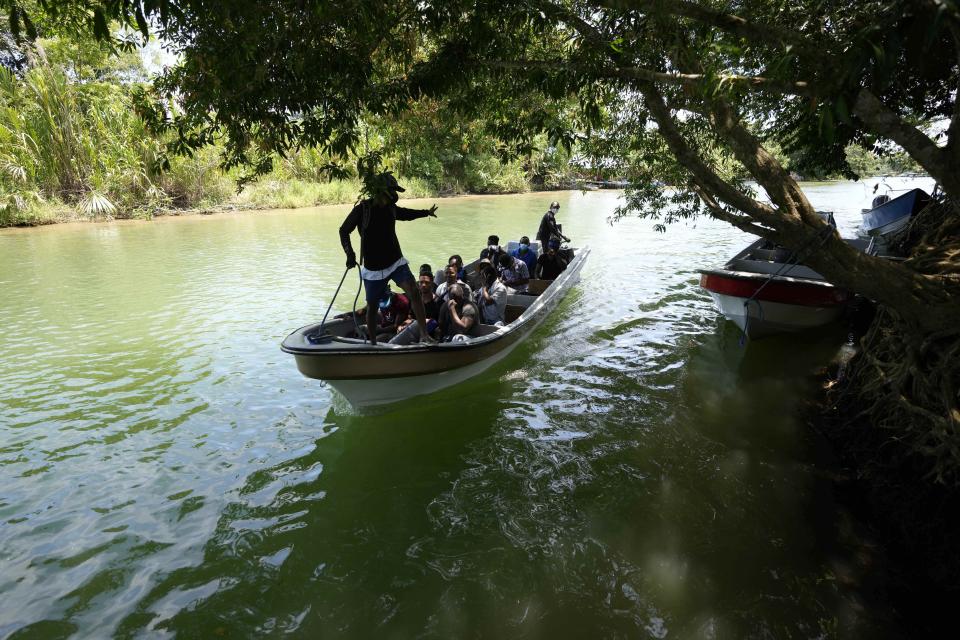 Migrants arrive on a boat to Acandi, Colombia, Tuesday, Sept. 14, 2021. The migrants, following a well-beaten, multi-nation journey towards the U.S., will continue their journey through the jungle known as the Darien Gap. (AP Photo/Fernando Vergara)