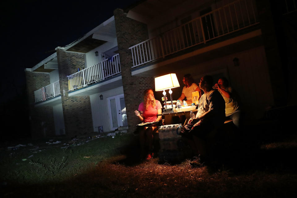 Danica Cherico and Shawn Gehlert use a generator to power a lamp outside their apartments, which lack electricity in Panama City.