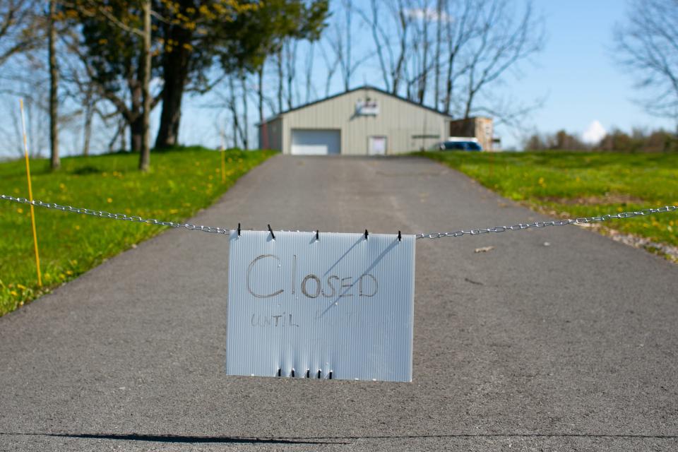 A closed sign hangs outside S&S Sales in Auburn, New York. The shop has been open, but by appointment only, during the stay-at-home order.