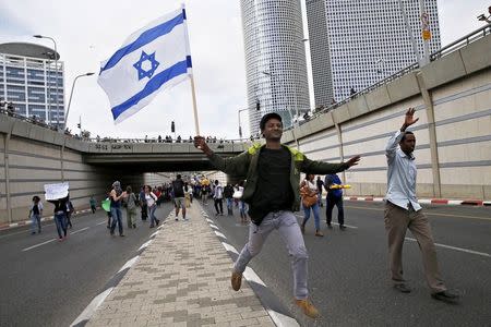 Protesters, mainly who are Israeli Jews of Ethiopian origin, run at a main road in Tel Aviv as they block it during a demonstration against what they say is police racism and brutality, after the emergence last week of a video clip that showed policemen shoving and punching a black soldier May 3, 2015. REUTERS/Baz Ratner