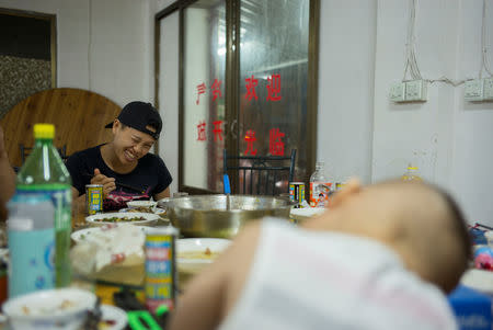 Huang Wensi spends time with her son where she works, before sending her son back to her hometown in Lianjiang, Guangdong province, in Cixi county, Zhejiang province, China, June 28, 2018. REUTERS/Yue Wu