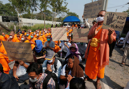 A Buddhist monk holds a placard as they gather outside Dhammakaya temple in Pathum Thani province, Thailand February 20, 2017. REUTERS/Chaiwat Subprasom