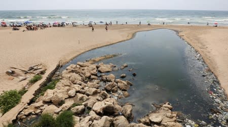 People swim at Ramlet al-Bayda public beach near a sewage outlet in Beirut