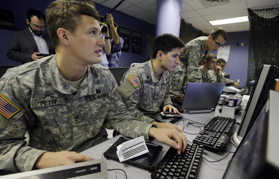 United States Military Academy cadet Brian Petty, left, watches data on a computers with, fellow cadets, at the Cyber Research Center at the United States Military Academy in West Point, N.Y., Wednesday, April 9, 2014. The West Point cadets are fending off cyber attacks this week as part of an exercise involving all the service academies. The annual Cyber Defense Exercise requires teams from the five service academies to create computer networks that can withstand attacks from the National Security Agency and the Department of Defense. (AP Photo/Mel Evans)