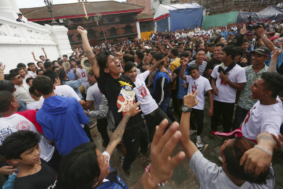 Devotees dance during Indra Jatra festival, an eight-day festival that honors Indra, the Hindu god of rain, in Kathmandu, Nepal, Friday, Sept. 13, 2019. The girl child revered as the Living Goddess Kumari is pulled around Kathmandu in a wooden chariot, families gather for feasts and at shrines to light incense for the dead, and men and boys in colorful masks and gowns representing Hindu deities dance to the beat of traditional music and devotees' drums, drawing tens of thousands of spectators to the city's old streets. (AP Photo/Niranjan Shrestha)