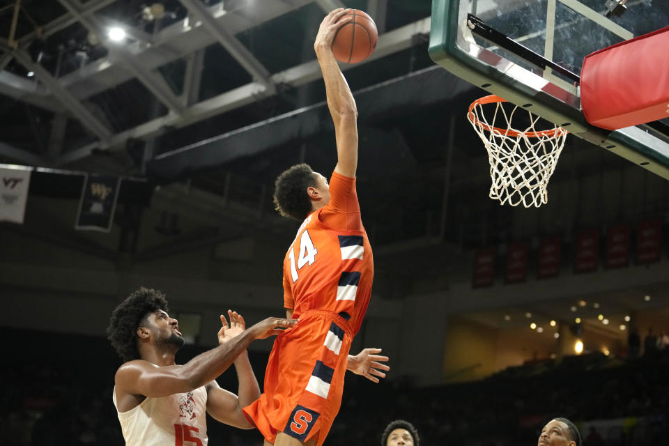 Syracuse center Jesse Edwards (14) dunks over Miami forward Norchad Omier (15) during the second half of an NCAA college basketball game, Monday, Jan. 16, 2023, in Coral Gables, Fla. (AP Photo/Lynne Sladky)