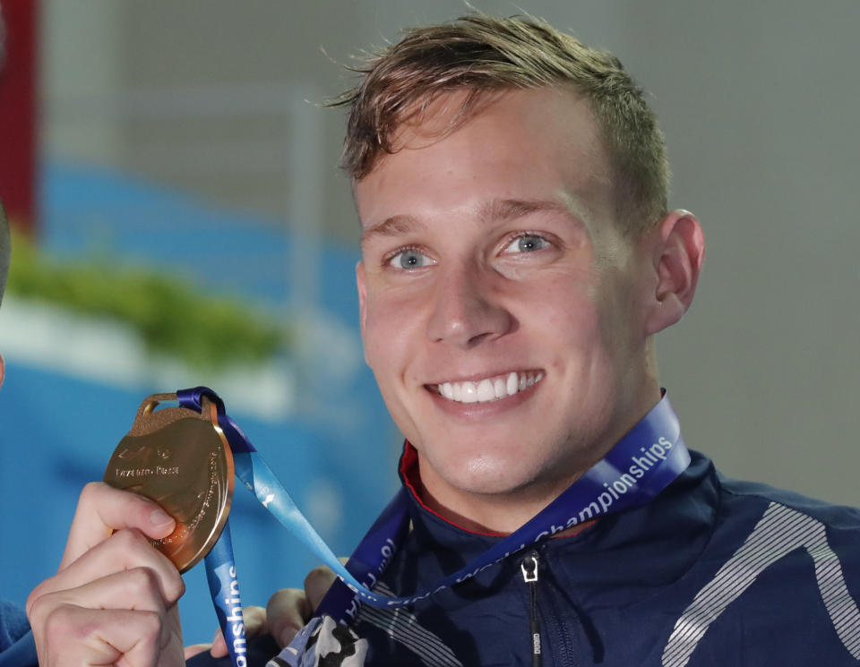 File-This July 27, 2019, file photo shows gold medalist United States' Caeleb Dressel posing with his gold medal following the men's 50m freestyle final at the World Swimming Championships in Gwangju, South Korea. In the post-Michael Phelps world, Dressel fits snugly into the successor's slot. Coming off two dynamic performances at the world swimming championships, Dressel figures to be one of the biggest stars at the 2020 Tokyo Games. Yet he is reticent to step into the spotlight. (AP Photo/Lee Jin-man, File)