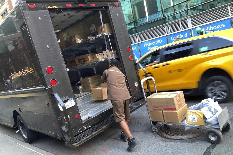 A United Parcel Service driver loads his truck, adjacent to a UPS Store, in New York, Thursday, May 11, 2023. More than 340,000 unionized United Parcel Service employees, including drivers and warehouse workers, say they are prepared to strike if the company does not meet their demands before the end of the current contract on July 31. (AP Photo/Richard Drew)