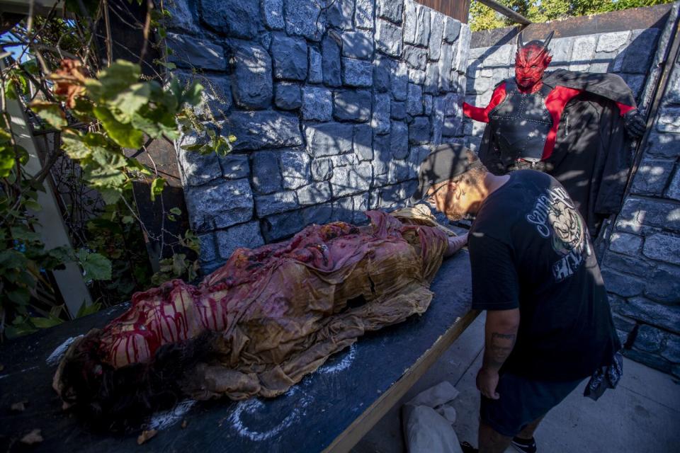 Jesus Garcia, right, views the beginning stages of his haunted house in Santa Ana.