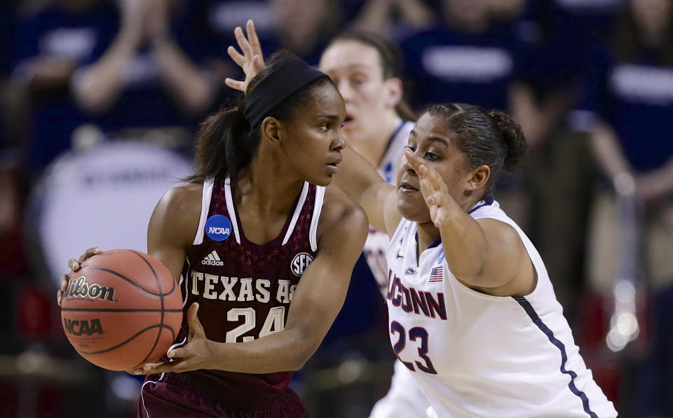 Texas A&M's Jordan Jones (24) is defended by Connecticut's Kaleena Mosqueda-Lewis (23) during the first half of a regional final game in the NCAA college basketball tournament in Lincoln, Neb., Monday, March 31, 2014. (AP Photo/Nati Harnik)