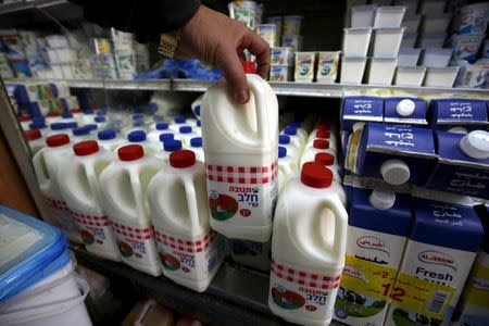 A man shows a bottle of milk produced by Israeli food-maker Tnuva at a supermarket in the West Bank city of Ramallah March 22, 2016. FOOD REUTERS/Mohamad Torokman